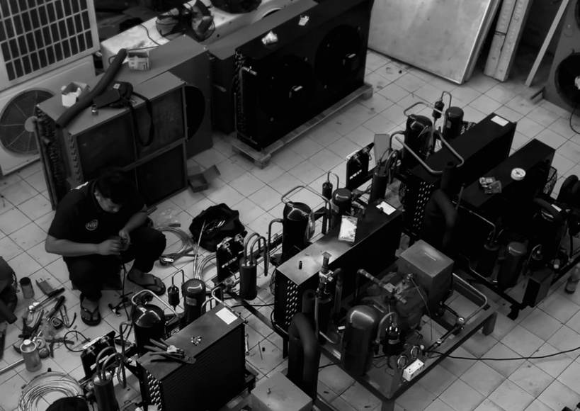 Teknisi merakit unit kondensor di workshop